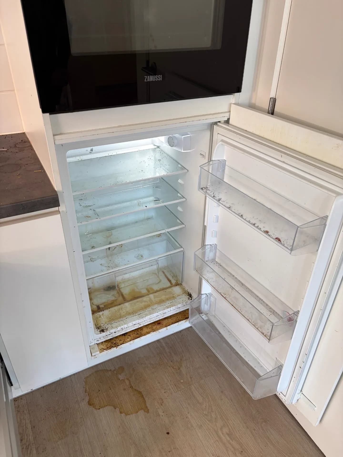 Koelkast met vuil en resten vóór de dieptereiniging