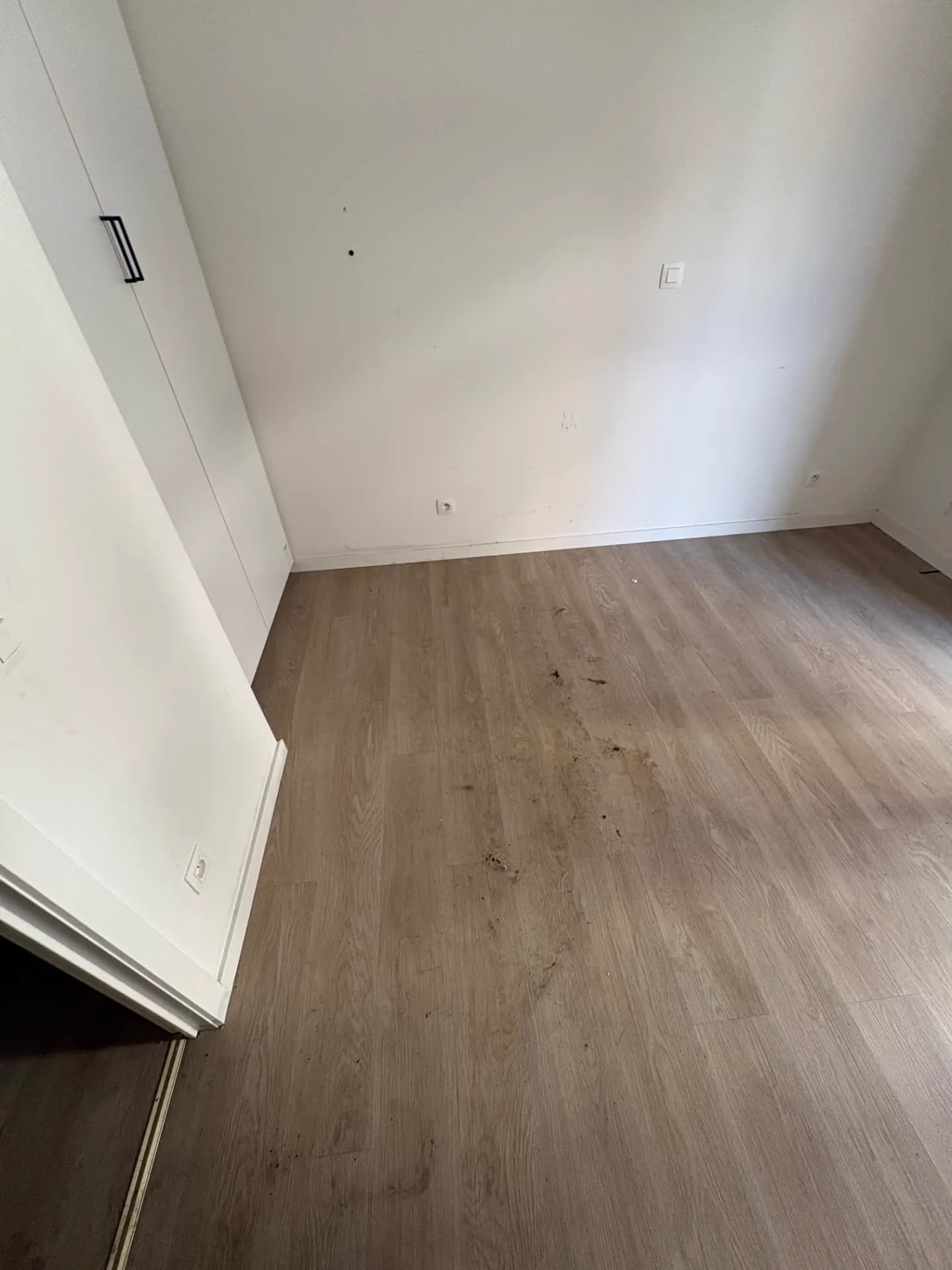 Vervuilde vloer en plinten in de kamer vóór de reiniging