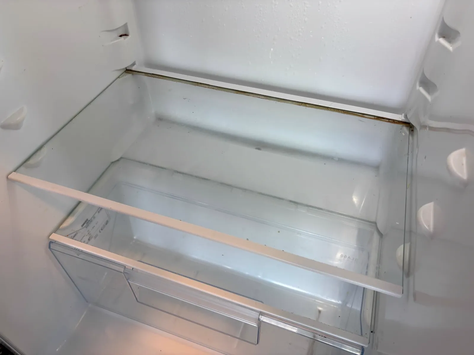 Glasplaten en laden van de koelkast vóór de reiniging